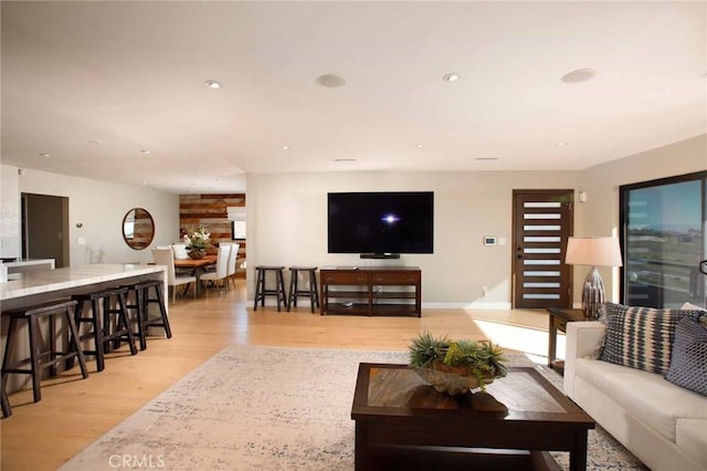 living area with recessed lighting and light wood finished floors