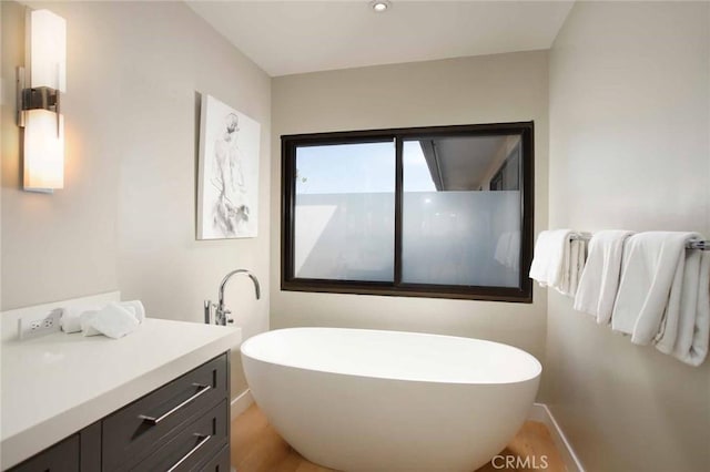 full bath featuring a freestanding bath and vanity