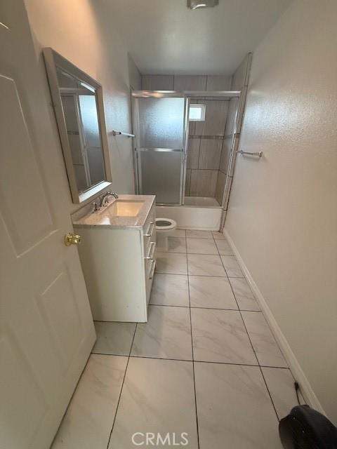 bathroom featuring vanity, toilet, baseboards, and bath / shower combo with glass door