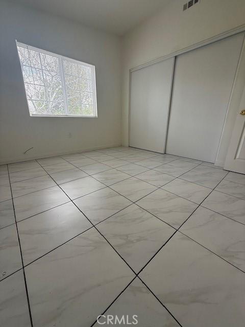 unfurnished bedroom featuring visible vents and a closet