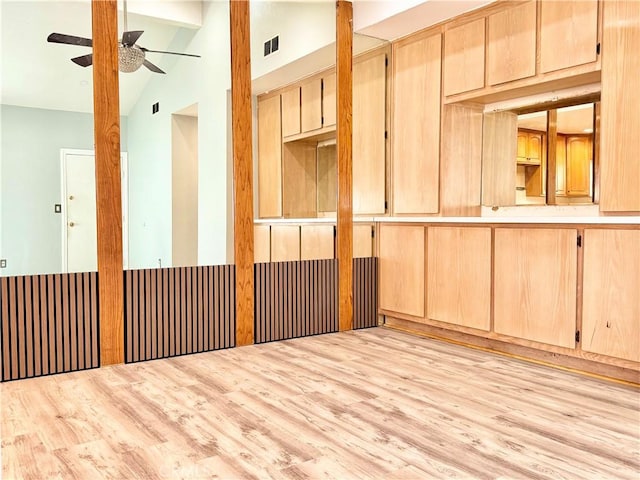 empty room featuring light wood-type flooring, visible vents, lofted ceiling with beams, and ceiling fan