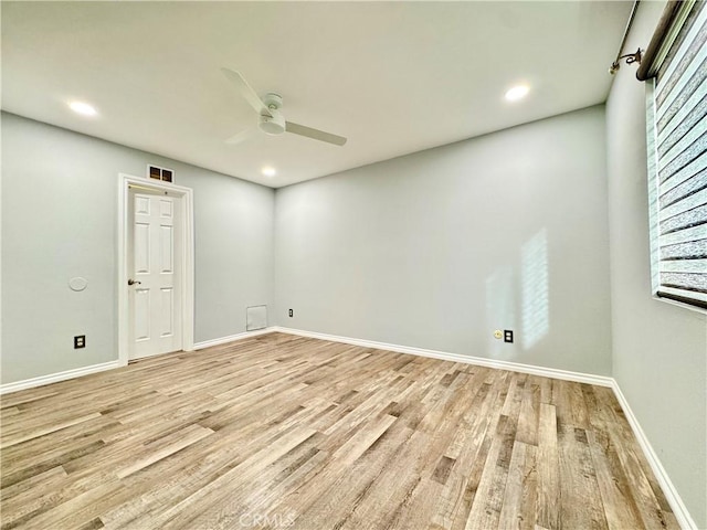 empty room with light wood-type flooring, visible vents, baseboards, and a ceiling fan