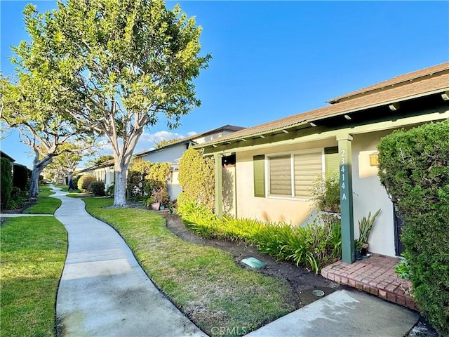 view of property exterior featuring stucco siding and a lawn