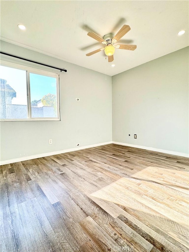 unfurnished room featuring recessed lighting, wood finished floors, baseboards, and ceiling fan