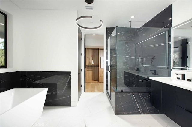 bathroom featuring vanity, a soaking tub, visible vents, and a stall shower