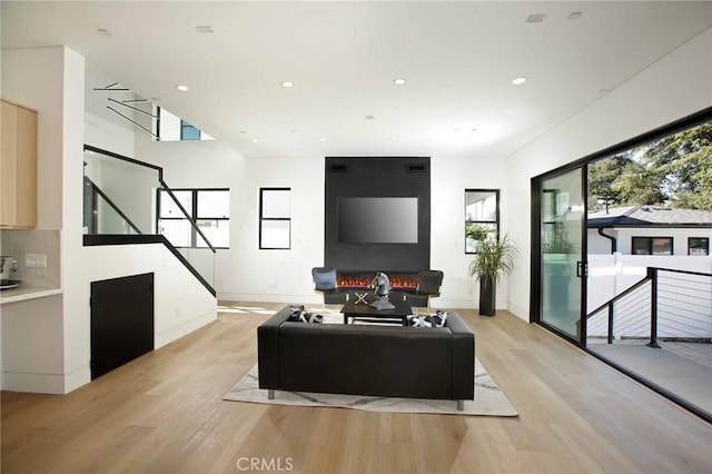 living room with a wealth of natural light, baseboards, light wood-style flooring, and recessed lighting