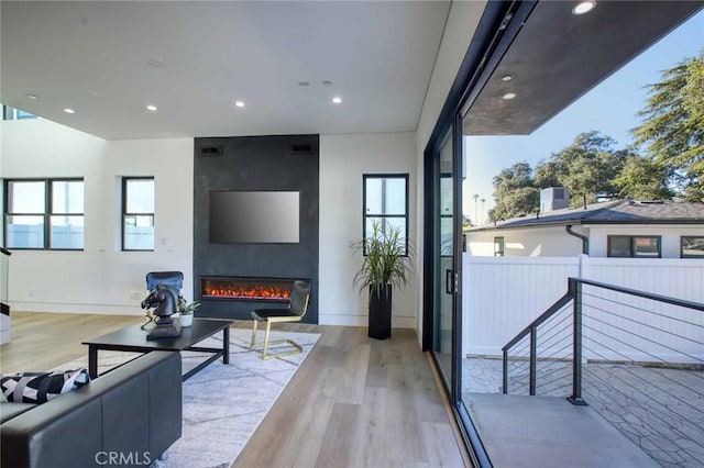 living area featuring recessed lighting, baseboards, wood finished floors, and a fireplace