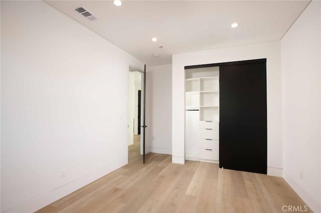 unfurnished bedroom with light wood-type flooring, visible vents, baseboards, and recessed lighting