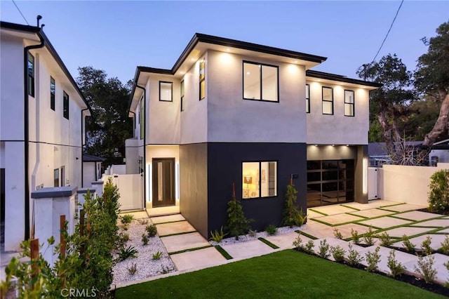 rear view of house featuring stucco siding, a patio area, a garage, and fence