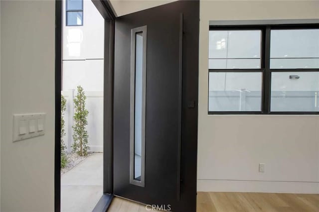 foyer with elevator, wood finished floors, and expansive windows