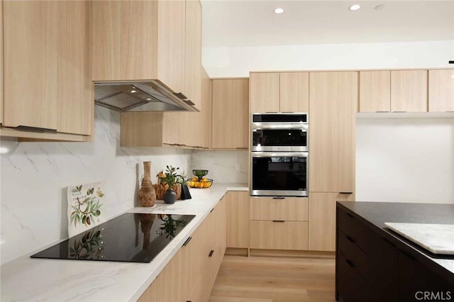 kitchen featuring light wood-style flooring, light brown cabinetry, decorative backsplash, double oven, and black electric stovetop