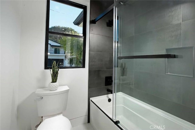 bathroom with combined bath / shower with glass door and toilet