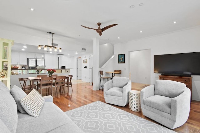 living room with recessed lighting, decorative columns, and light wood-style floors