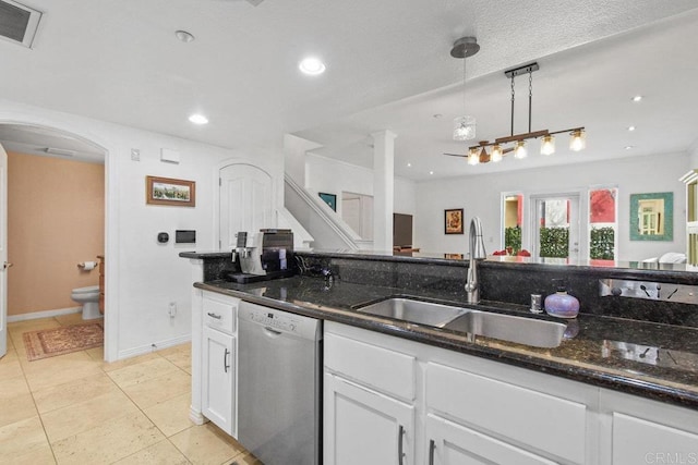 kitchen featuring visible vents, white cabinetry, arched walkways, a sink, and stainless steel dishwasher