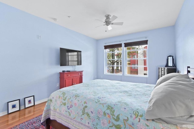 bedroom with wood finished floors, baseboards, and ceiling fan