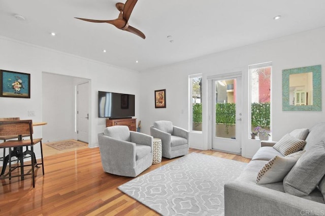 living area with a ceiling fan, crown molding, recessed lighting, and light wood-style floors