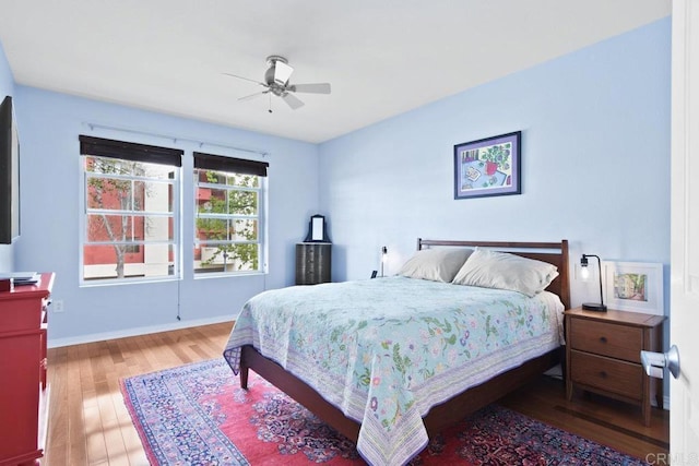 bedroom featuring ceiling fan, baseboards, and wood finished floors