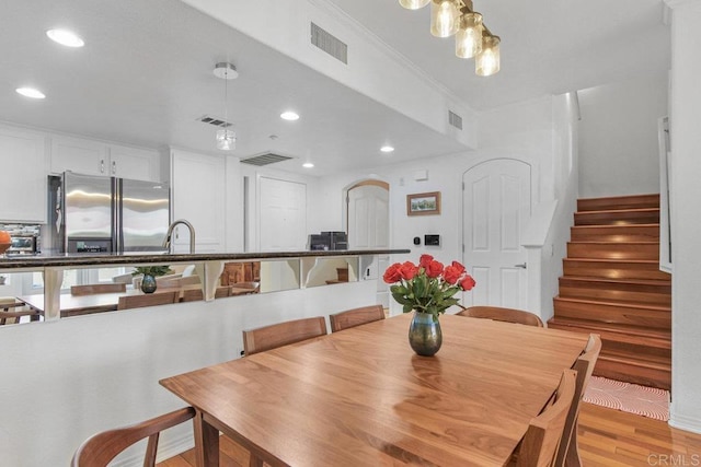 dining room with stairs, visible vents, and light wood finished floors