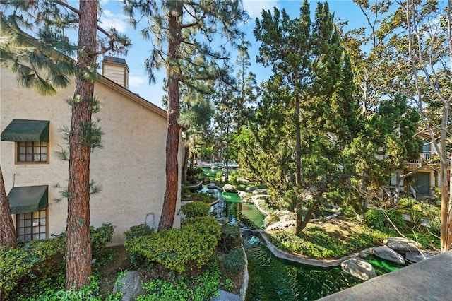 view of side of home featuring a chimney and stucco siding