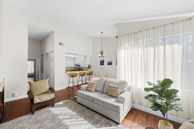 living area featuring plenty of natural light, wood finished floors, visible vents, and a textured ceiling