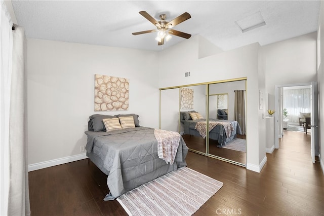 bedroom featuring lofted ceiling, attic access, wood finished floors, and a closet