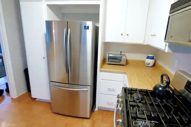 534 Dover Ct, Lake Arrowhead, CA 92352 - kitchen featuring stainless steel appliances, light countertops, white cabinets, and light wood-type flooring