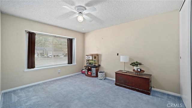 miscellaneous room with baseboards, a textured ceiling, carpet, and ceiling fan