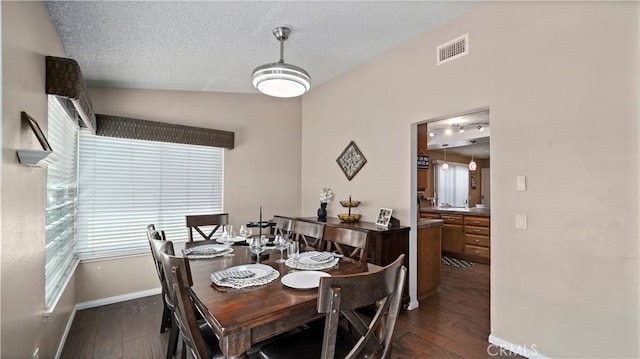 dining space featuring visible vents, baseboards, dark wood-type flooring, and a textured ceiling