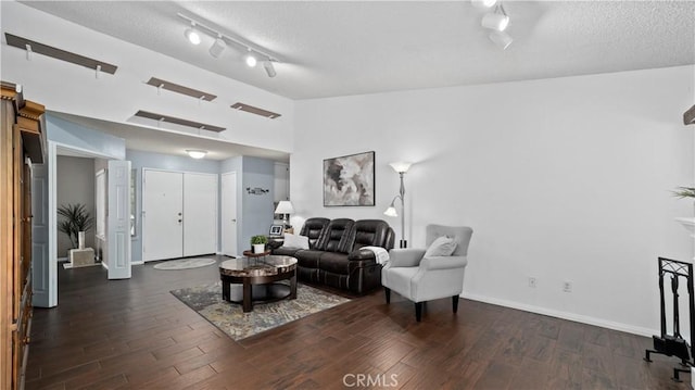 living area featuring a textured ceiling, wood finished floors, and vaulted ceiling