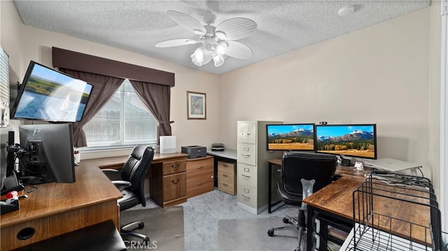 office featuring light carpet, a textured ceiling, and ceiling fan