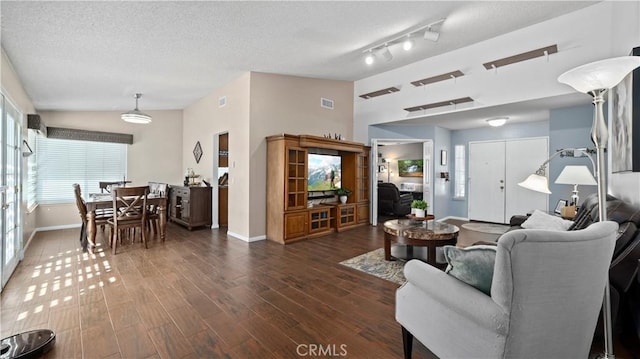 living room with visible vents, lofted ceiling, a textured ceiling, wood finished floors, and baseboards