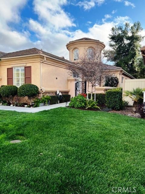 view of front of property featuring stucco siding and a front yard