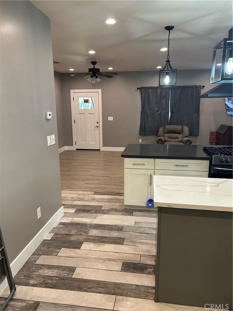 kitchen featuring recessed lighting, baseboards, wood finished floors, and ceiling fan