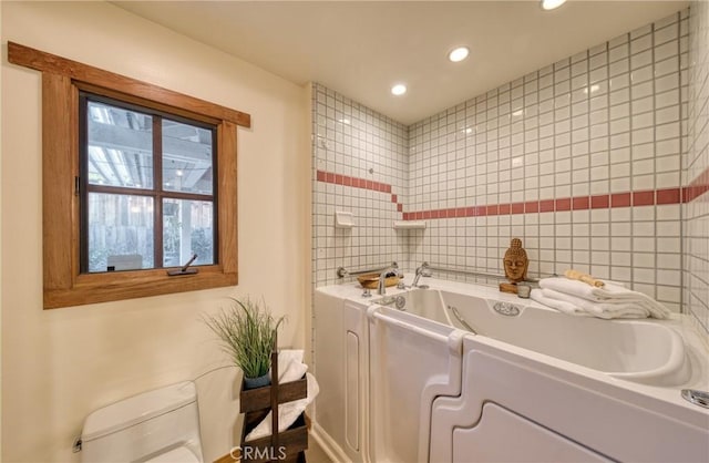 bathroom with recessed lighting, toilet, tile walls, and a bath