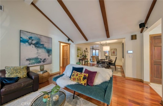 living room with baseboards, visible vents, high vaulted ceiling, beamed ceiling, and light wood-type flooring