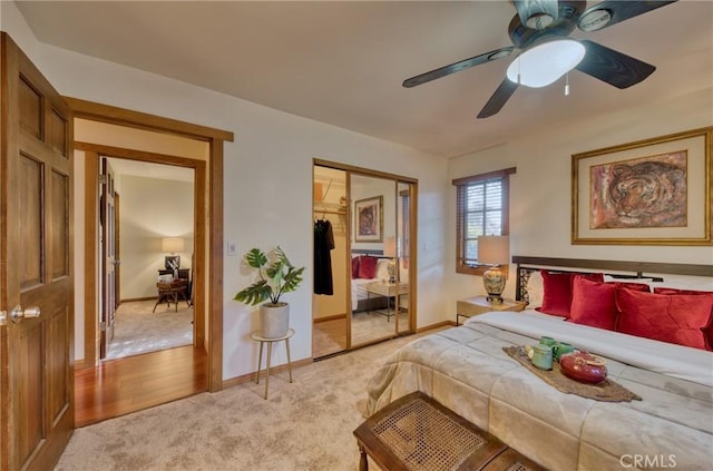 bedroom featuring ceiling fan, baseboards, a closet, and light carpet