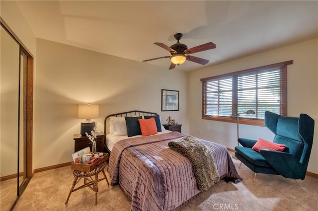 bedroom with a closet, baseboards, carpet, and ceiling fan