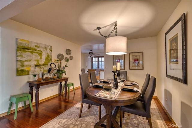 dining area featuring a ceiling fan, baseboards, and wood finished floors