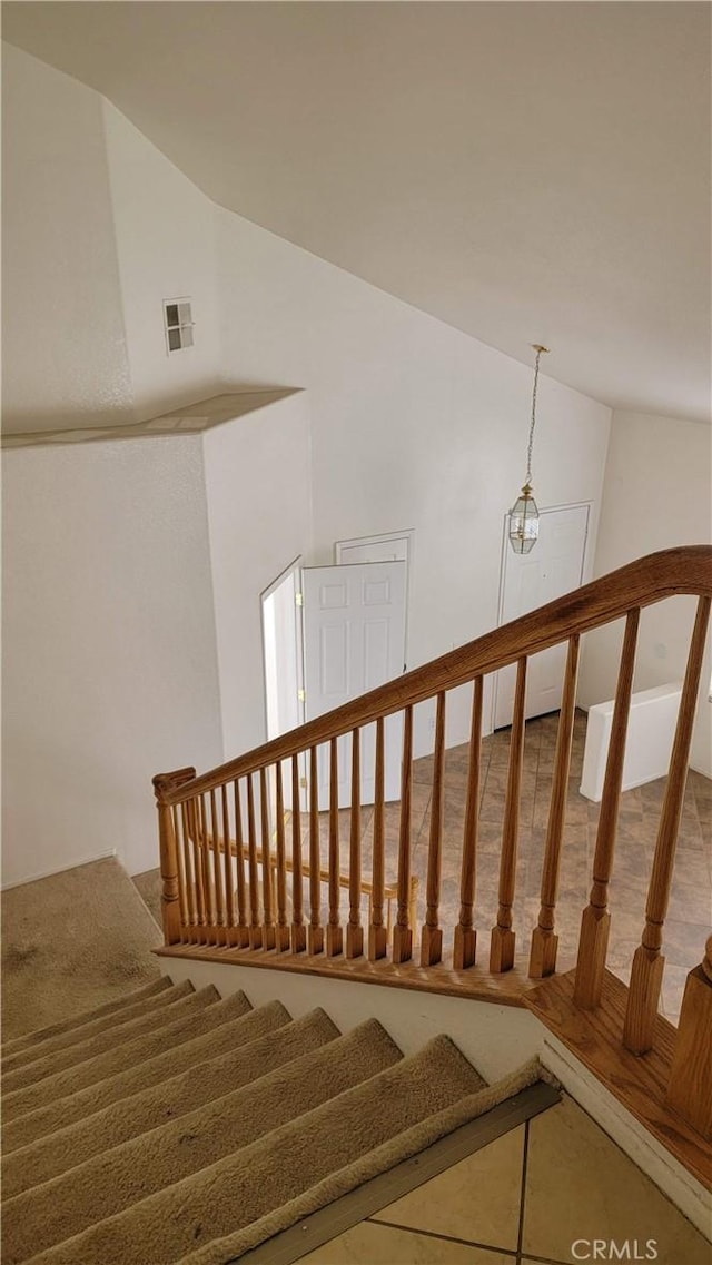 staircase with visible vents and lofted ceiling