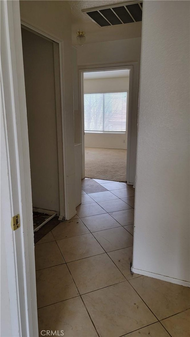 hallway with light tile patterned flooring and visible vents