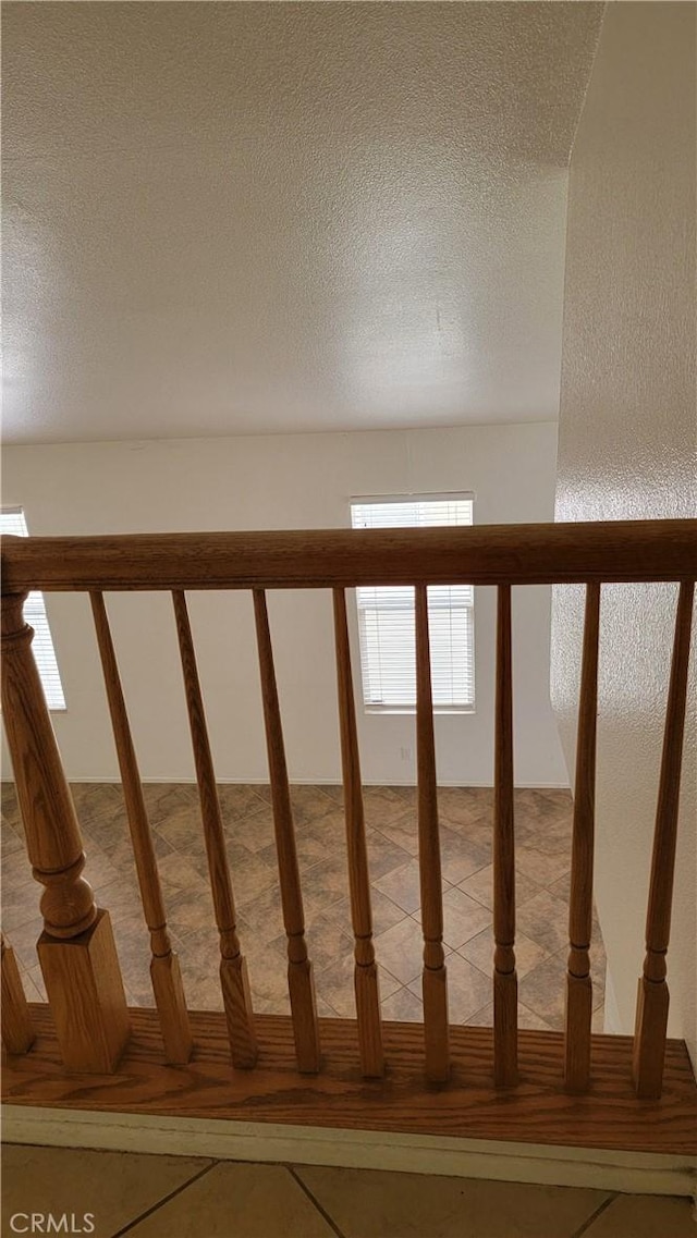 staircase with tile patterned flooring and a textured ceiling