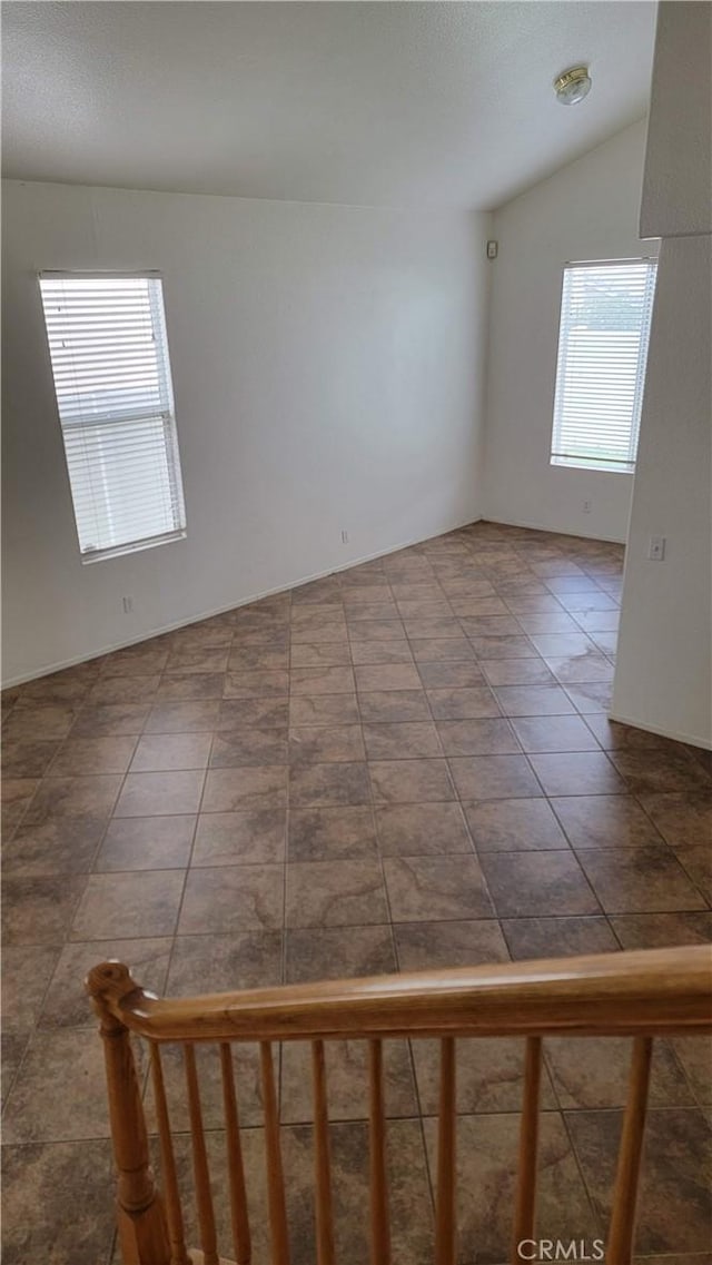 unfurnished room featuring vaulted ceiling