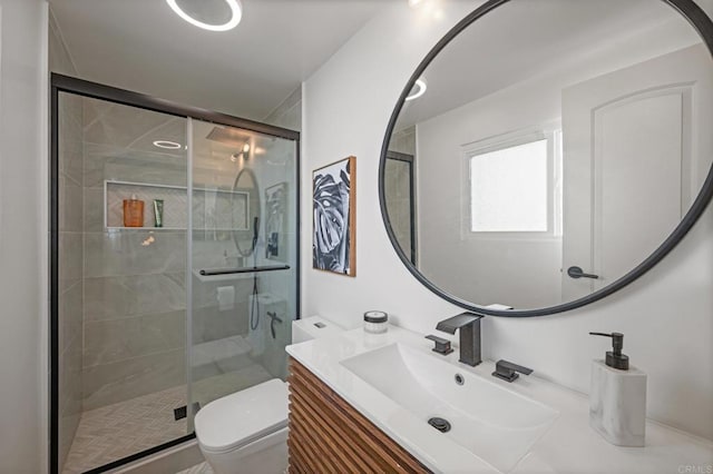 bathroom with a stall shower, toilet, and vanity