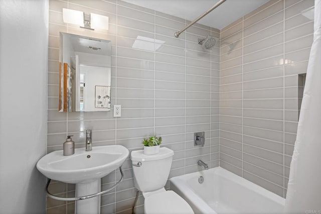 bathroom featuring backsplash, shower / bathtub combination with curtain, toilet, and tile walls