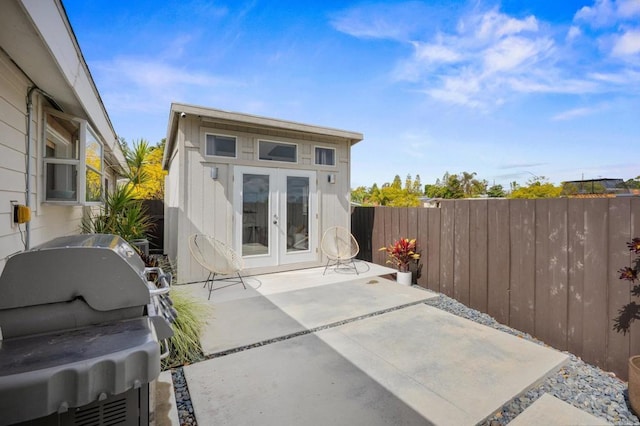 view of patio with fence, french doors, and a grill