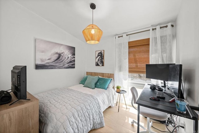 bedroom with lofted ceiling and wood finished floors