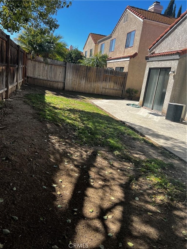 view of yard featuring central air condition unit, a patio, and a fenced backyard