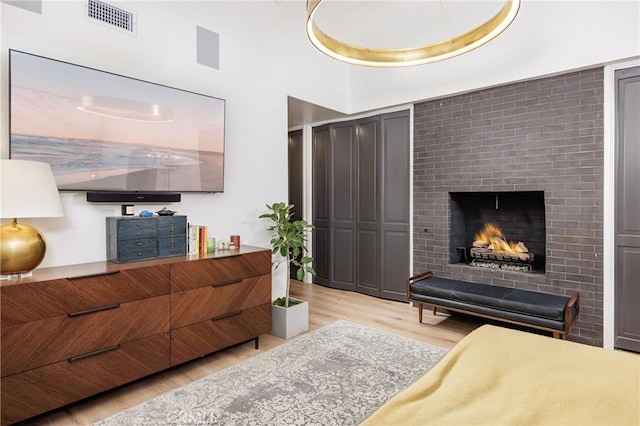 living area featuring visible vents, light wood-style flooring, and a fireplace