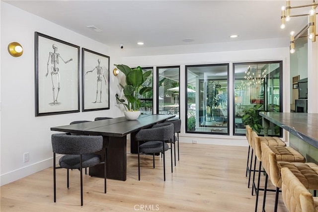 dining space with baseboards, visible vents, recessed lighting, light wood-style floors, and a notable chandelier