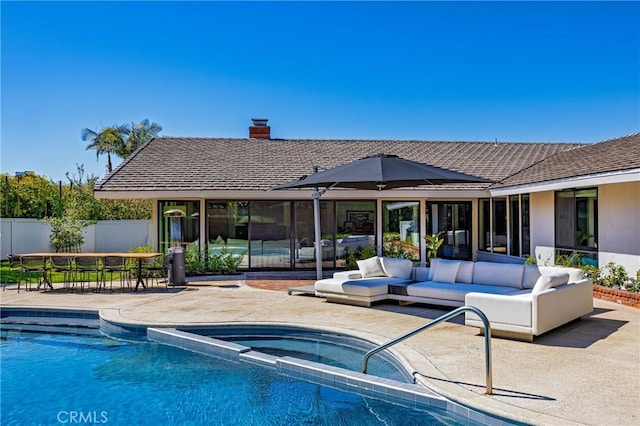 view of swimming pool featuring outdoor lounge area, an in ground hot tub, fence, and a patio area